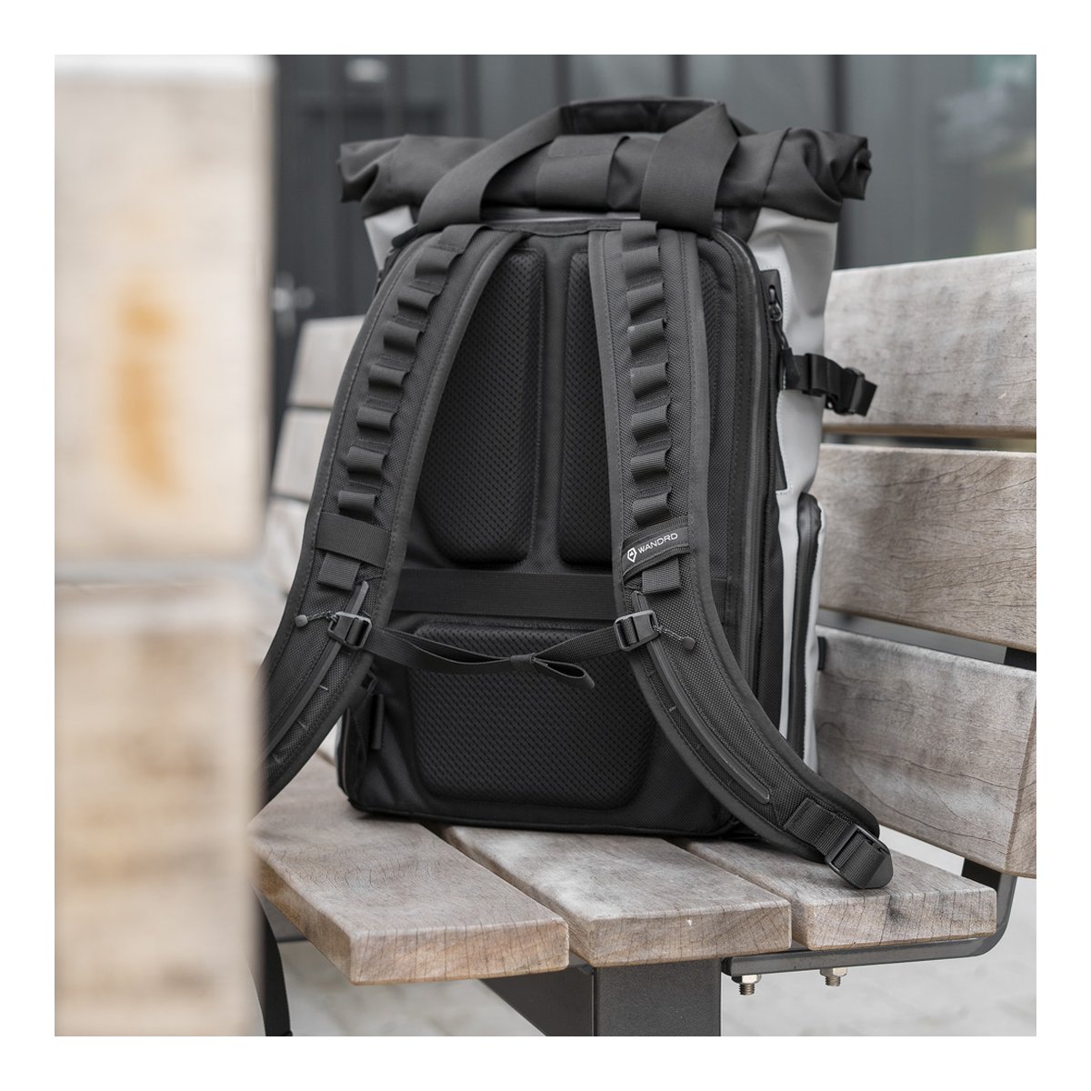 WANDRD PRVKE 21-Liter DisNet Grey Photo Bundel V3 - Rückansicht des schwarzen Rucksacks mit gepolstertem Rückenteil und Schultergurten auf Holzbank. WANDRD PRVKE 21-Liter DisNet Grey Photo Bundel V3 - Rückansicht des schwarzen Rucksacks mit gepolstertem Rückenteil und Schultergurten auf Holzbank.