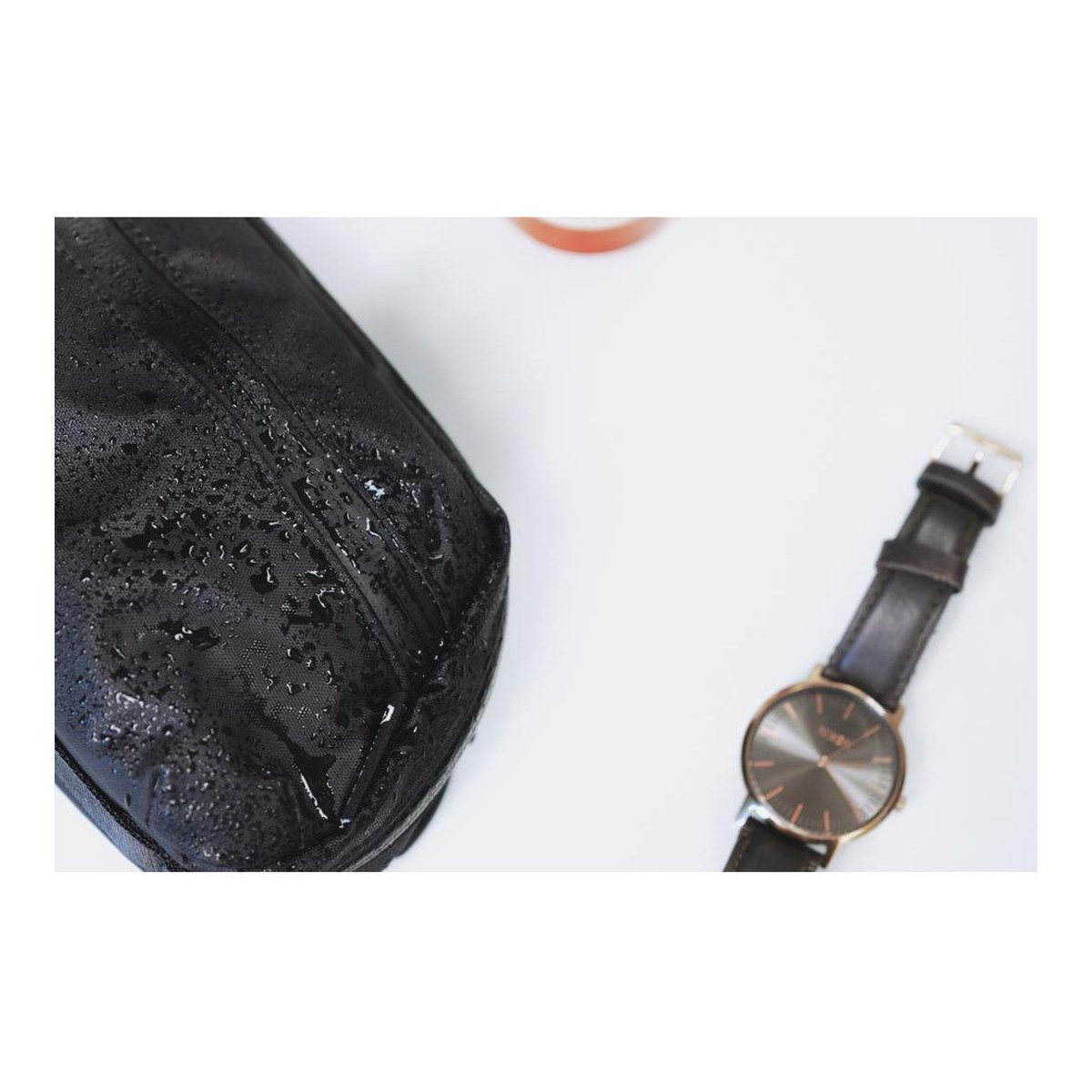 WANDRD Toiletry Bag Medium - Detailansicht wasserabweisende Tasche und Uhr