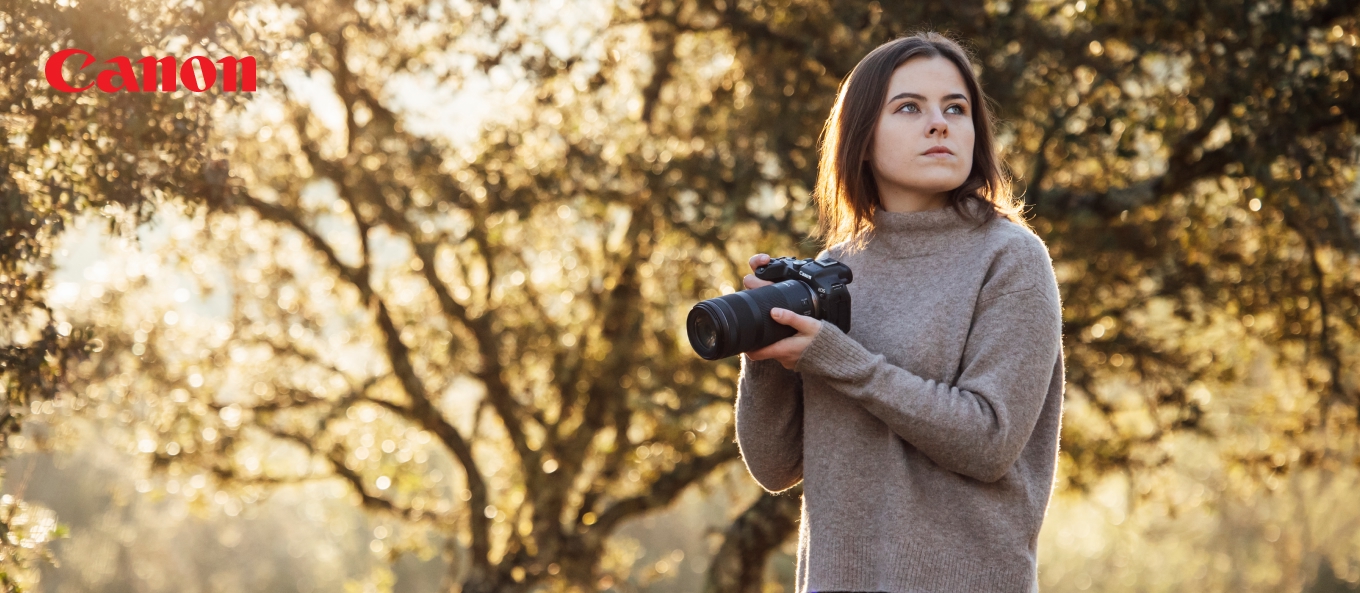 Fotografin mit Canon APS-C Systemkamera bei Sonnenuntergang im Wald
