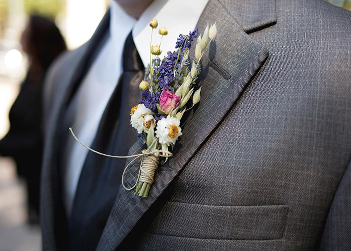 Detailaufnahme des Blumenansteckers am Anzug des Bräutigams – Hochzeitsfotografie mit Canon EOS R5 Mark II