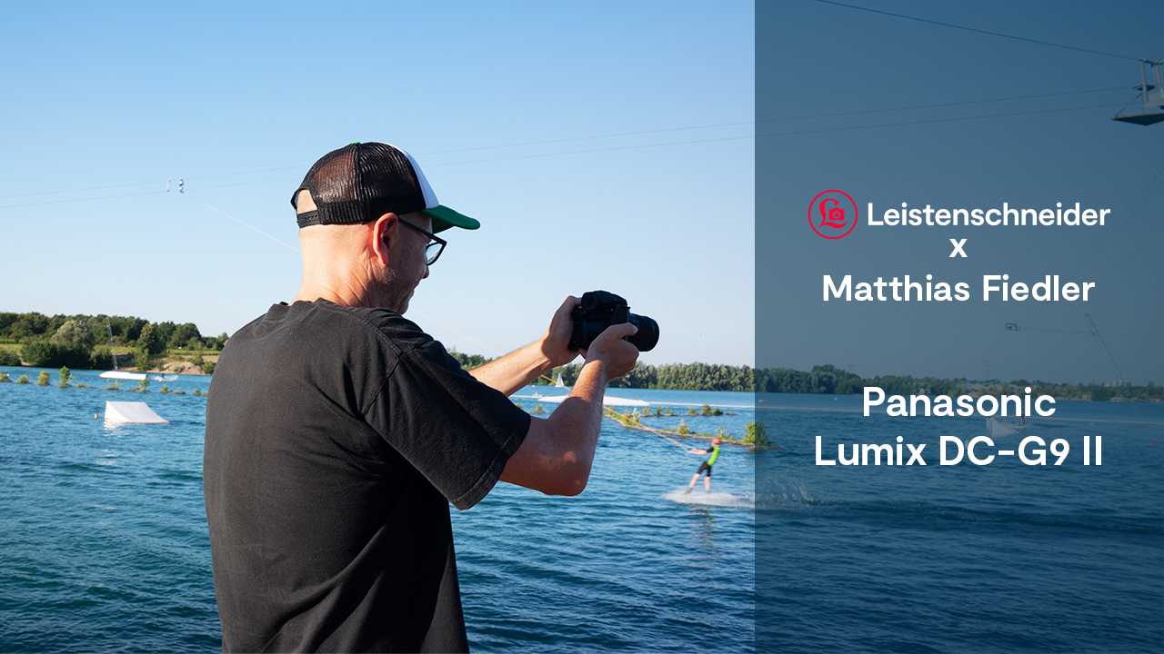 Matthias Fiedler vor einem See mit der Panasonic Lumix DC-G9 II fotografiert Windsurfer