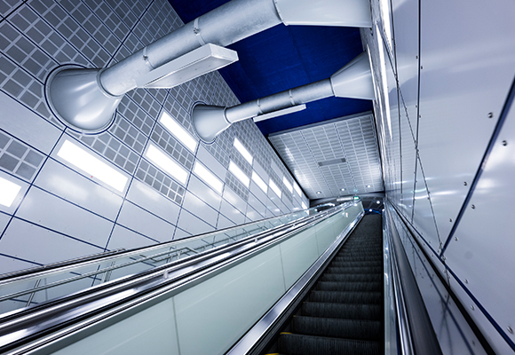 Architekturfotografie – Rolltreppe in futuristischer U-Bahn-Station Architekturfoto mit dem Sony 16-25mm f/2.8 Weitwinkelobjektiv – symmetrische Linienführung und starke Bildtiefe.