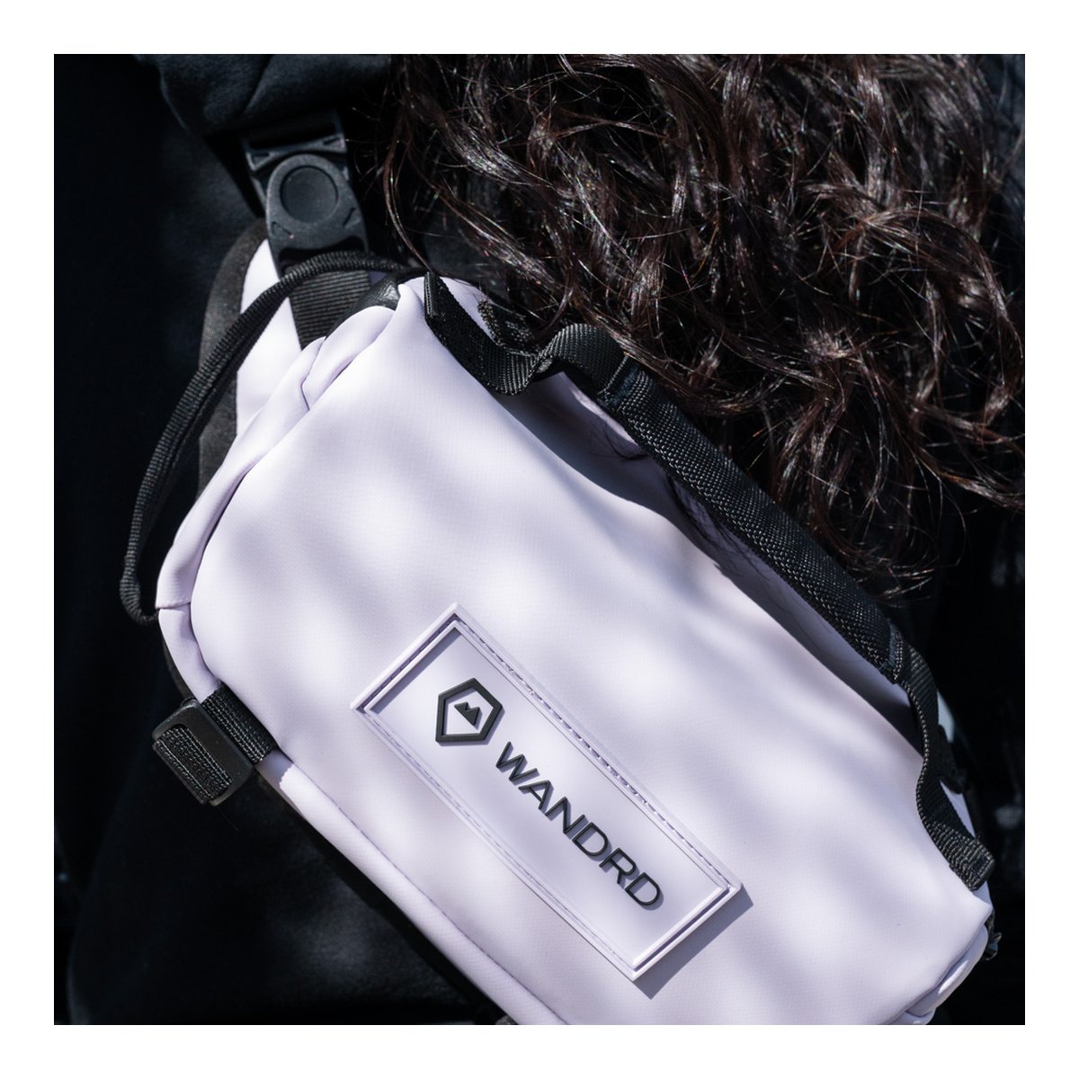 WANDRD ROGUE Sling 3L Uyuni Purple - Anwendungsbeispiel: Lila Sling Bag auf dem Rücken getragen, mit WANDRD Logo. WANDRD ROGUE Sling 3L Uyuni Purple - Anwendungsbeispiel: Lila Sling Bag auf dem Rücken getragen, mit WANDRD Logo.