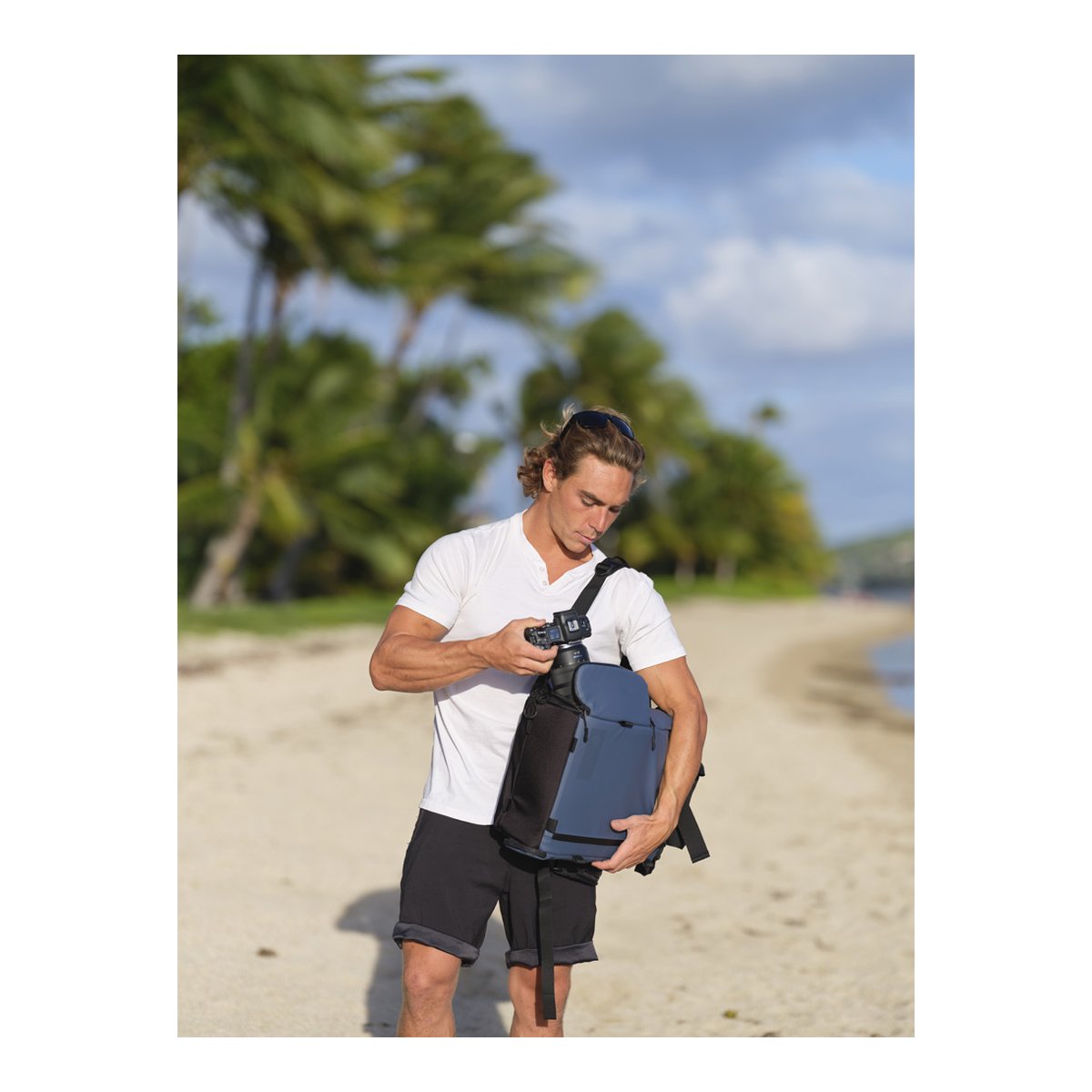 WANDRD PRVKE Lite 11-Liter Blue - Anwendungsbeispiel: Mann entnimmt Kamera aus dem Rucksack am Strand WANDRD PRVKE Lite 11-Liter Blue - Anwendungsbeispiel: Mann entnimmt Kamera aus dem Rucksack am Strand