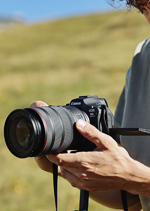 Person nutzt die Canon EOS R6 Mark III mit aufgeklapptem Display beim Fotografieren.