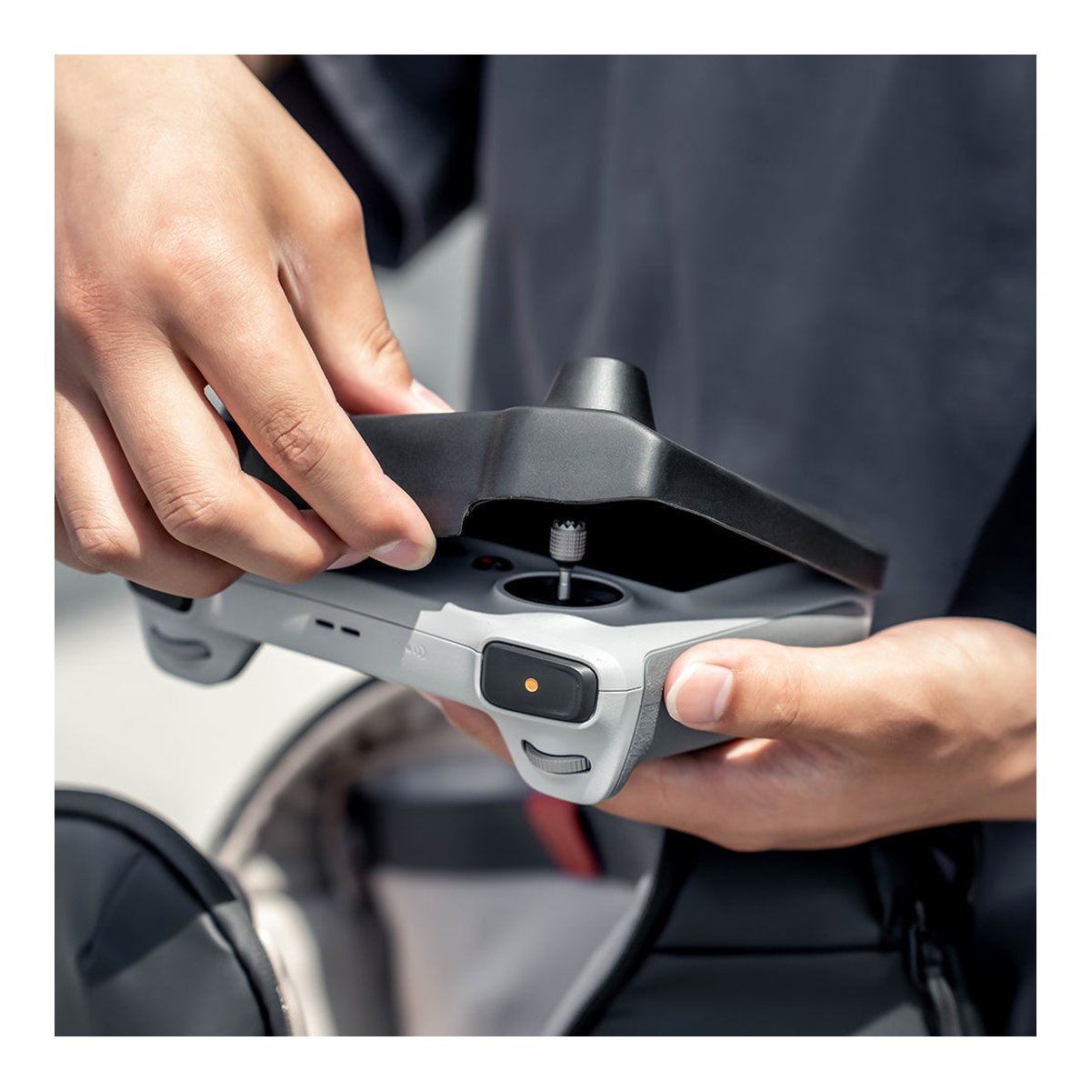 PGYTECH DJI RC Protector - Detailansicht: Hände befestigen Steuerknüppel an Drohnen-Fernbedienung.