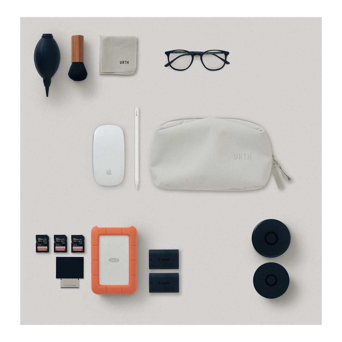 Urth Zeolite Tech Organiser (Beige) - Draufsicht auf eine flache Anordnung von Foto- und Tech-Accessoires: Blasebalg, Tuch, Maus, Speicher, Akkus, Tasche.