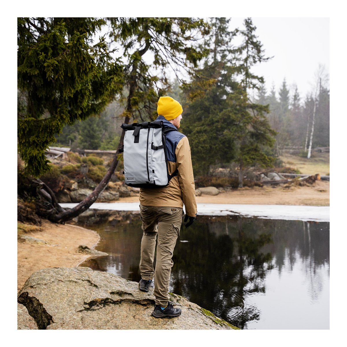 WANDRD PRVKE 41-Liter DisNet Grey Photo Bundel V3 - Anwendungsbeispiel: Rückansicht des Rucksacks auf Person im Wald am See WANDRD PRVKE 41-Liter DisNet Grey Photo Bundel V3 - Anwendungsbeispiel: Rückansicht des Rucksacks auf Person im Wald am See