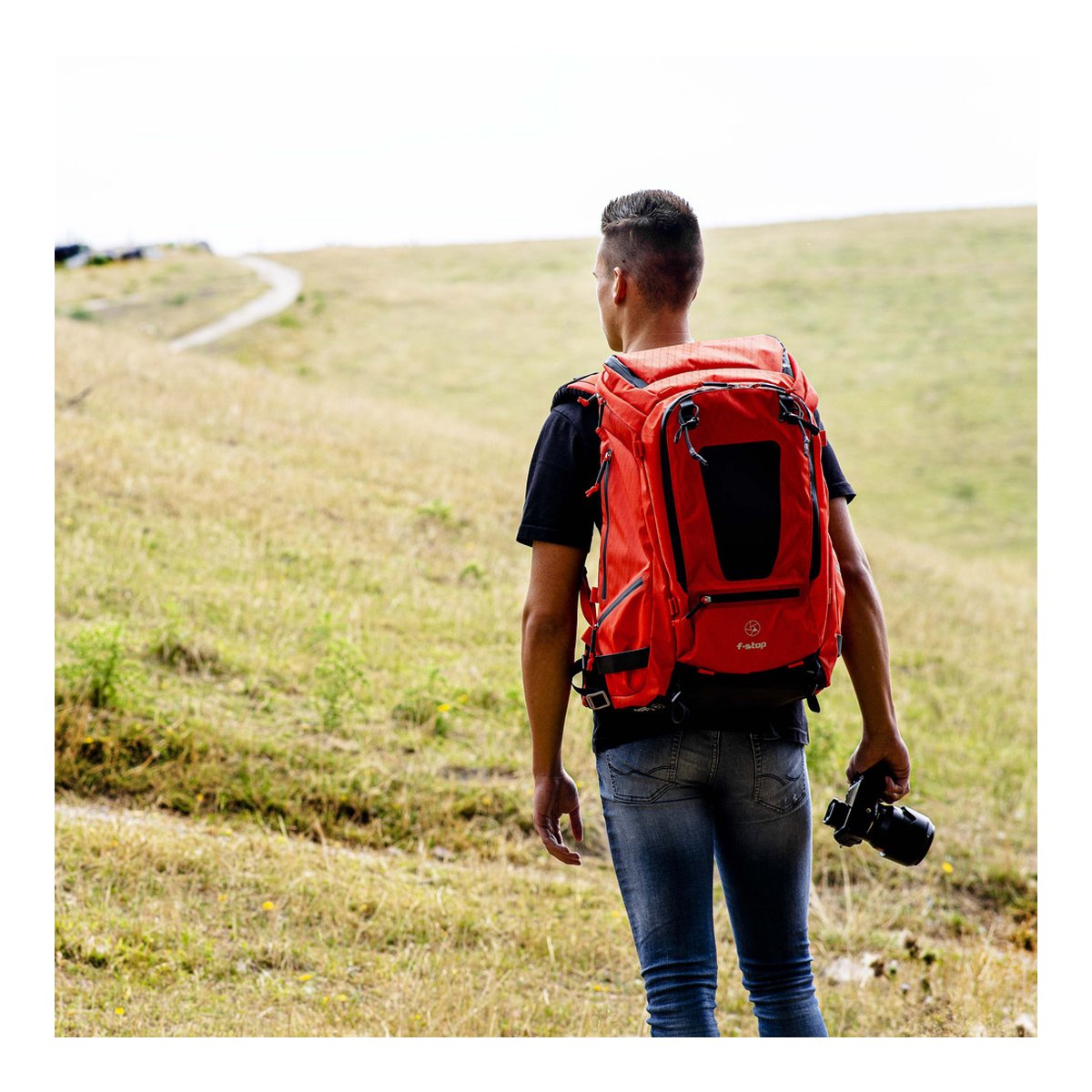 F-Stop DuraDiamond Tilopa - Magma - Anwendungsbeispiel: Rückansicht des roten Kamerarucksacks an einer Person. F-Stop DuraDiamond Tilopa - Magma - Anwendungsbeispiel: Rückansicht des roten Kamerarucksacks an einer Person.