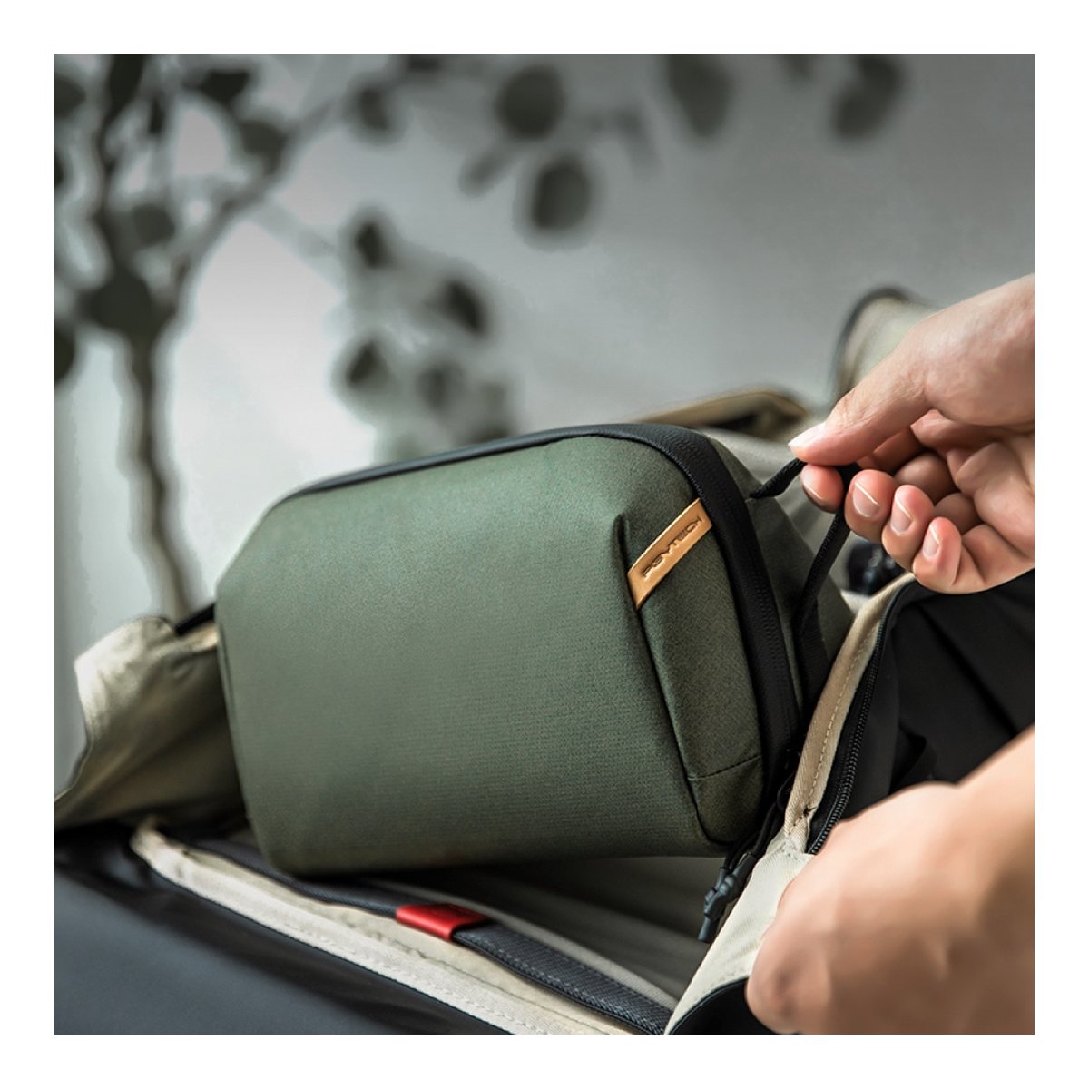 PGYTECH Wash Pouch(Twilight Black) - Anwendungsbeispiel: Verstauen der grünen Zubehörtasche in einem Rucksack.