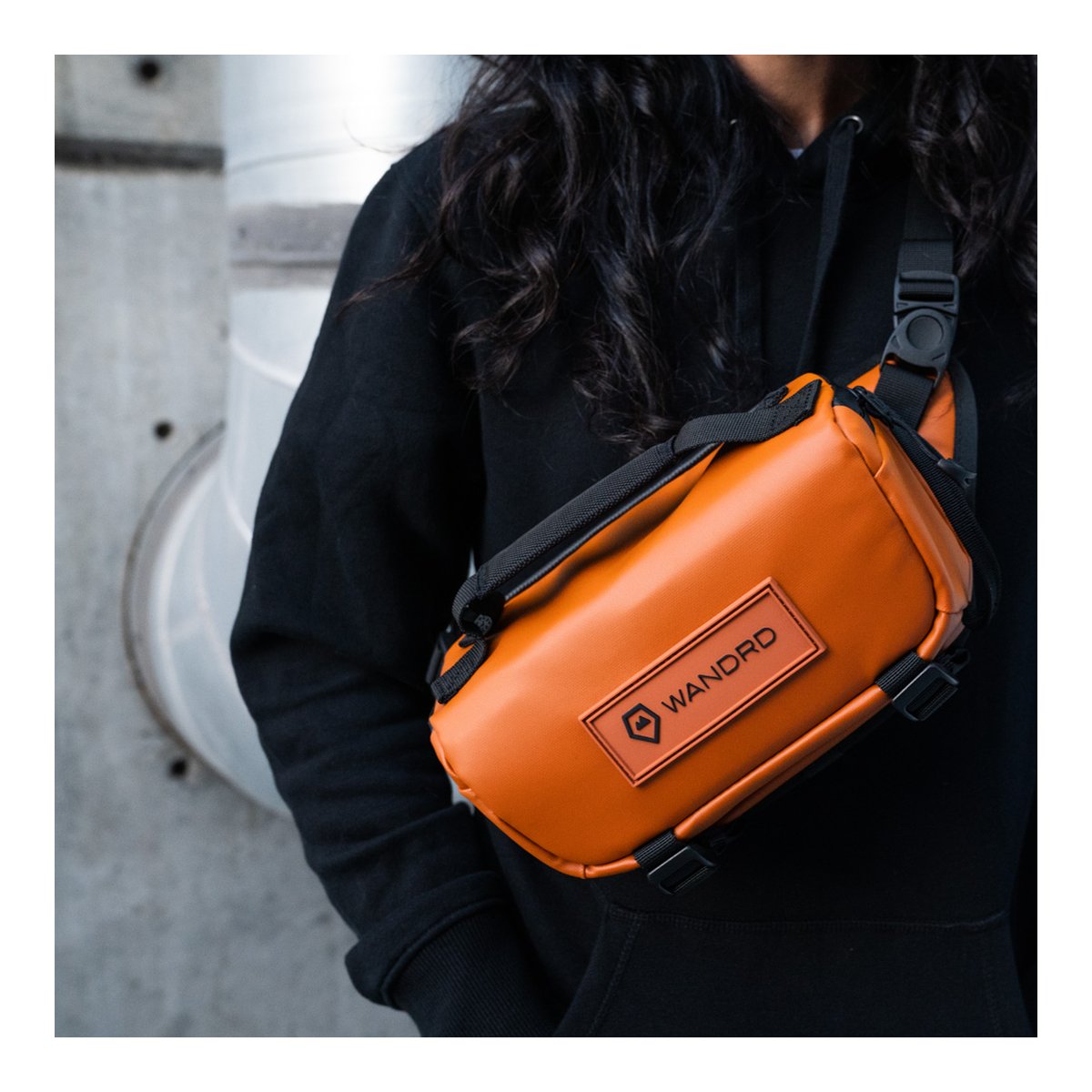 WANDRD ROGUE Sling 3L Sedona Orange - Anwendungsbeispiel: Orangefarbene WANDRD Sling Bag quer über der Brust getragen WANDRD ROGUE Sling 3L Sedona Orange - Anwendungsbeispiel: Orangefarbene WANDRD Sling Bag quer über der Brust getragen