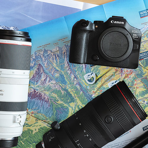 Canon EOS R6 Mark III und RF Objektive liegen auf einer Landkarte – Symbol für Reisefotografie.