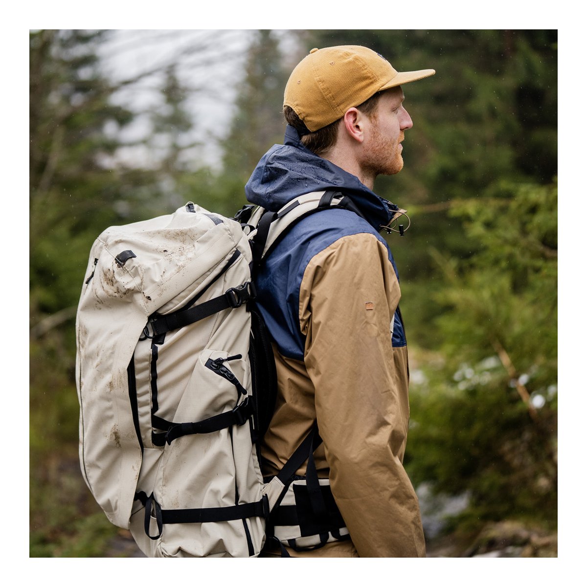 Wandrd Fernweh M/L Tan Photo Bundle - ANWENDUNGSBEISPIEL: Person von der Seite mit beigem Rucksack in der Natur.