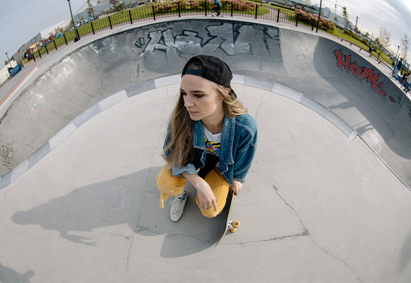 Fisheye-Fotografie – Weitwinkel-Perspektive mit starker Verzerrung Skaterin mit Baseballcap in einer Skatepark-Bowl, aufgenommen mit einem Fisheye-Objektiv. Die starke Verzerrung betont die Dynamik und gibt der Szene einen kreativen Look.