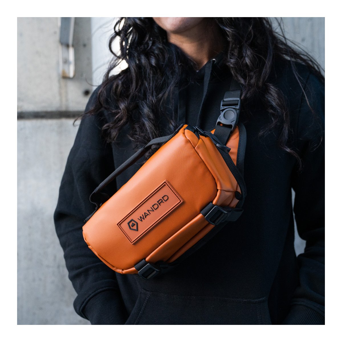 WANDRD ROGUE Sling 3L Sedona Orange - Anwendungsbeispiel: Orange WANDRD Sling Bag quer über Brust getragen WANDRD ROGUE Sling 3L Sedona Orange - Anwendungsbeispiel: Orange WANDRD Sling Bag quer über Brust getragen