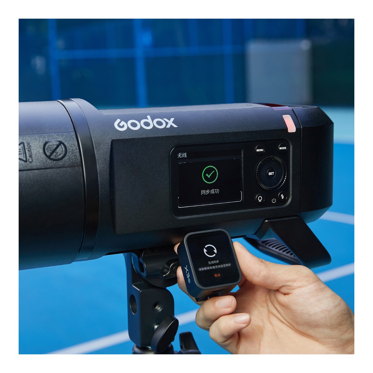 Godox Witstro AD600Pro II - Anwendungsbeispiel: Godox Blitzgerät mit erfolgreicher Synchronisierung zum Godox X3 Auslöser, der in einer Hand gehalten wird.