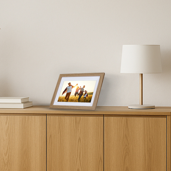 Digitaler Rollei Smart Frame im Wohnzimmer auf Sideboard in Holzoptik mit Familienfoto