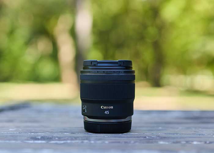 Canon RF 45mm 1.2 STM Objektiv steht im Freien auf einem Tisch.