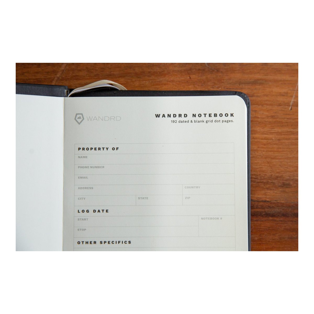 WANDRD NOTEBOOK Yellow - Detailansicht: Erste Seite des WANDRD Notizbuchs mit Feldern für Besitzerinfos & Logdaten.