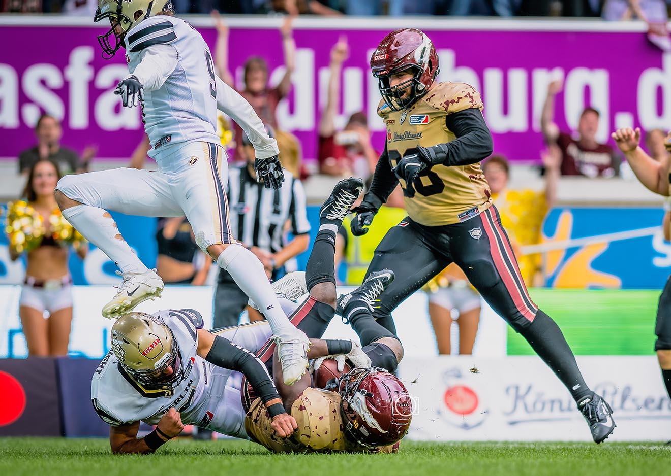 Dynamischer Tackle beim American Football – festgehalten im Workshop Intensive Szene beim American Football: Spieler wird während des Sportfotografie Workshops mit der Nikon Z-Kamera beim Tackle fotografiert.