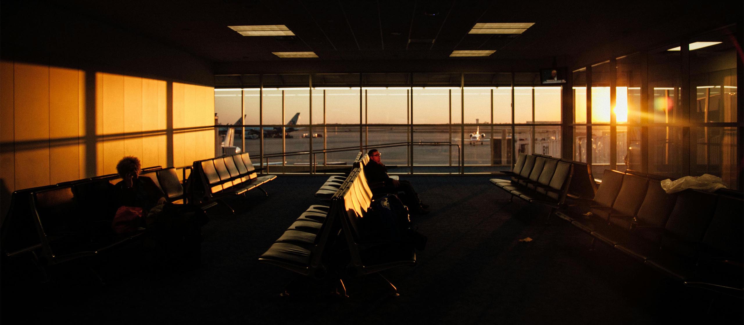 ThinkTank Ausrüstung – Sicher unterwegs auf Reisen Reisender am Flughafen im Sonnenaufgang – Symbolbild für mobile und zuverlässige Fototaschen von ThinkTank