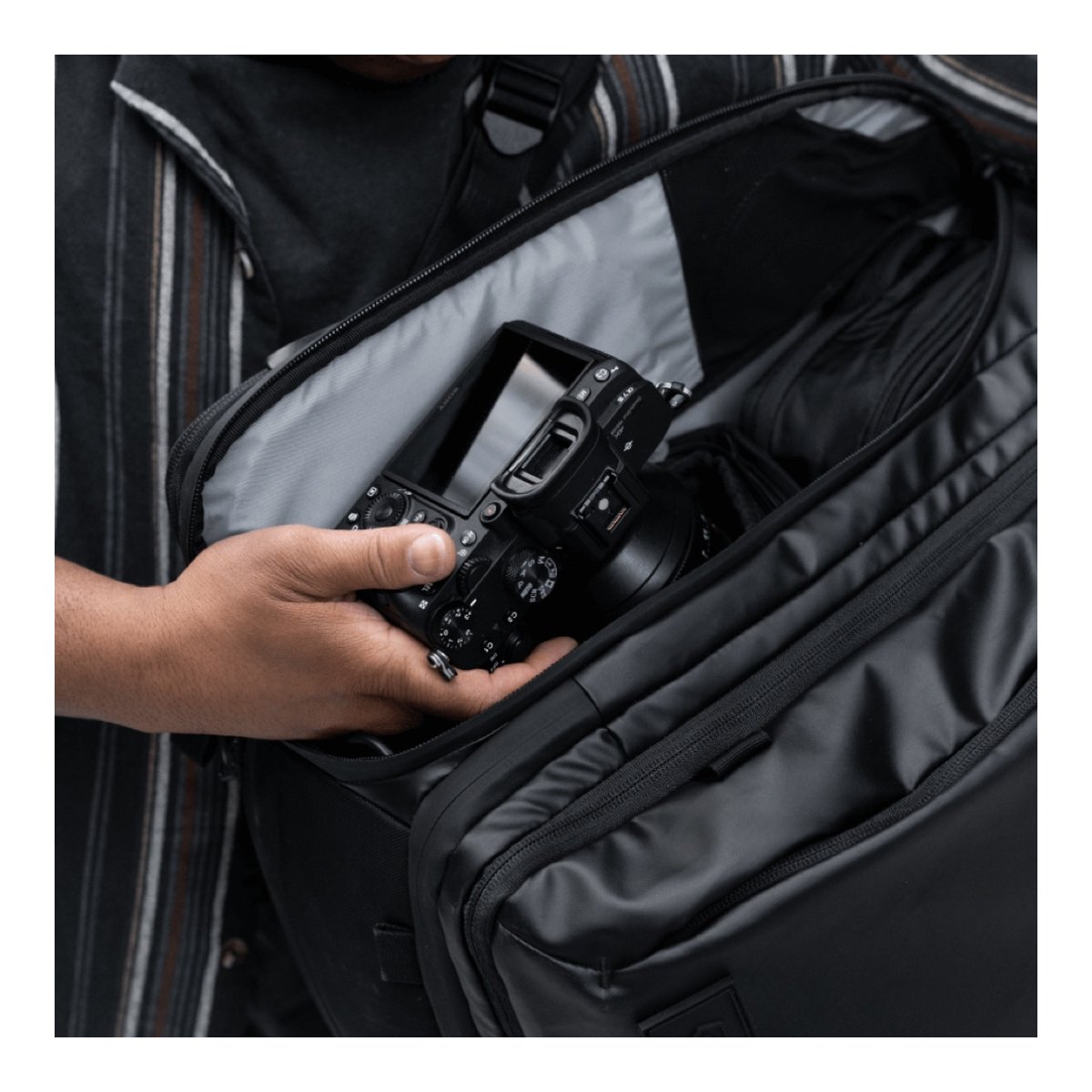 WANDRD Transit 45L Travel Backpack Black - Anwendungsbeispiel: Kamera wird in gepolstertes Fach der Tasche gelegt
