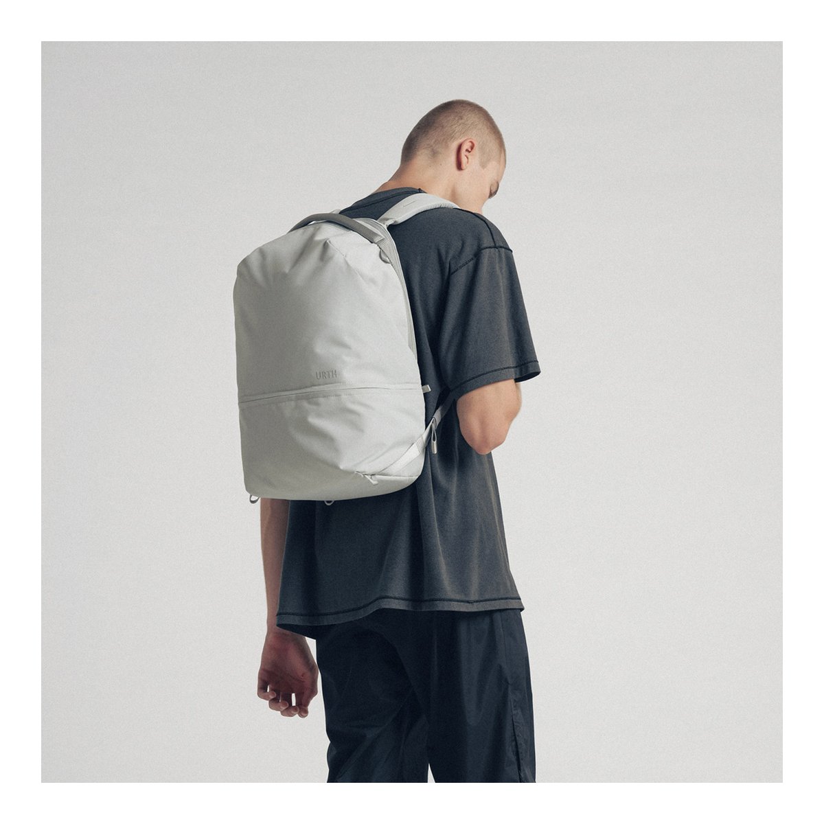 Urth Arkose 20L Rucksack + Kamera Insert (Aschgrau) - Anwendungsbeispiel am Rücken: Heller Rucksack an Person von hinten.