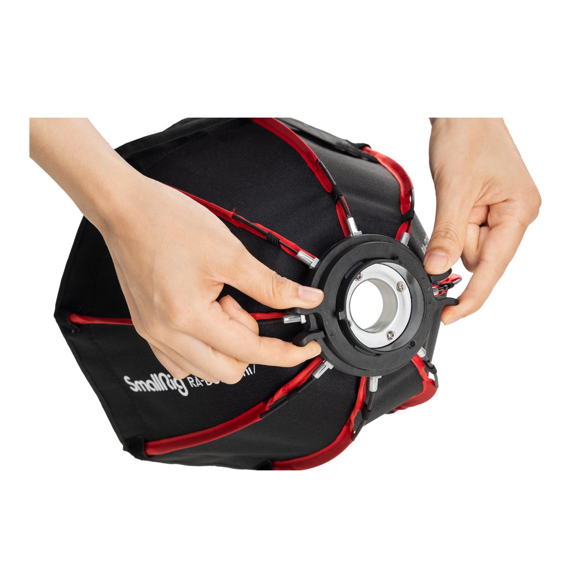 SmallRig 4358 RA-D30 Parabolic Softbox - Detailansicht: Hände befestigen Streben am Zentralring einer Softbox.
