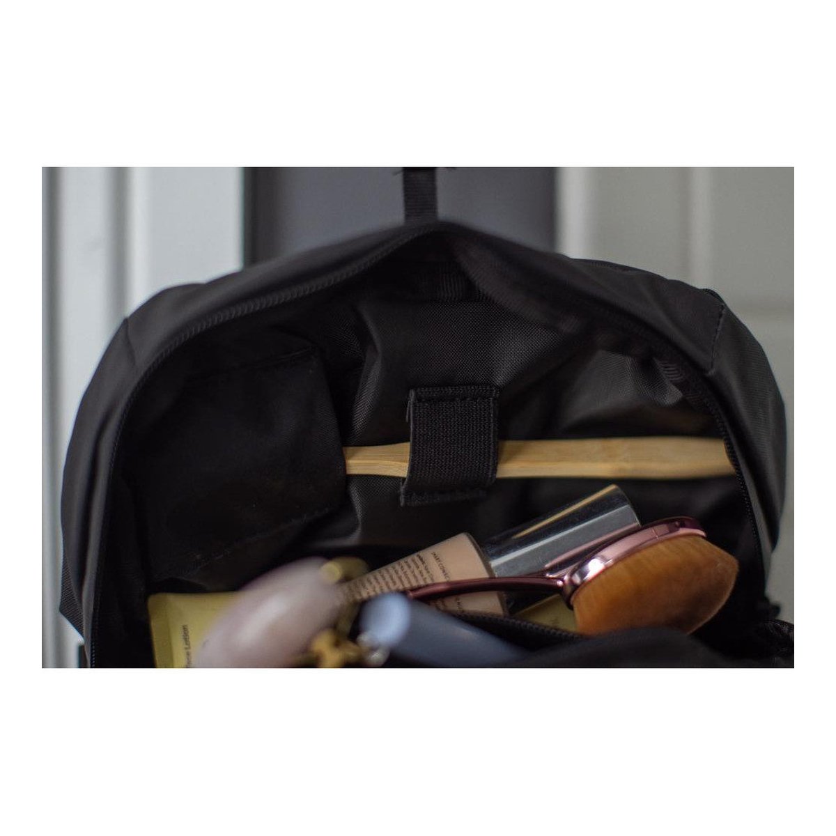 WANDRD Toiletry Bag Medium - Detailansicht: Innenraum des Rucksacks mit verstauter Kosmetik und Zahnbürste in Halterung.