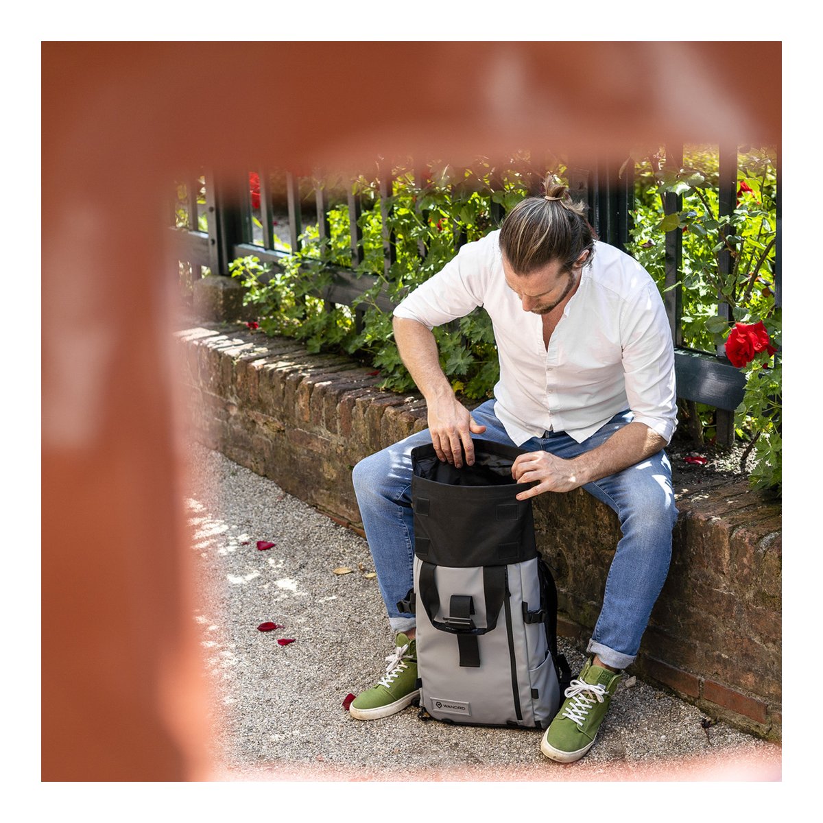 WANDRD PRVKE 21-Liter DisNet Grey Photo Bundel V3 - Anwendungsbeispiel: Mann greift in das offene Hauptfach des Rucksacks, sitzend im Park. WANDRD PRVKE 21-Liter DisNet Grey Photo Bundel V3 - Anwendungsbeispiel: Mann greift in das offene Hauptfach des Rucksacks, sitzend im Park.