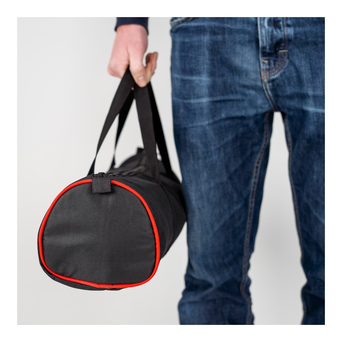 Caruba Curved Gesichtsreflektor Pro Set- 180cm x 65cm (inkl. Erweiterungsset) - Anwendungsbeispiel: Kleine schwarze Sporttasche mit rotem Rand, von Hand getragen.