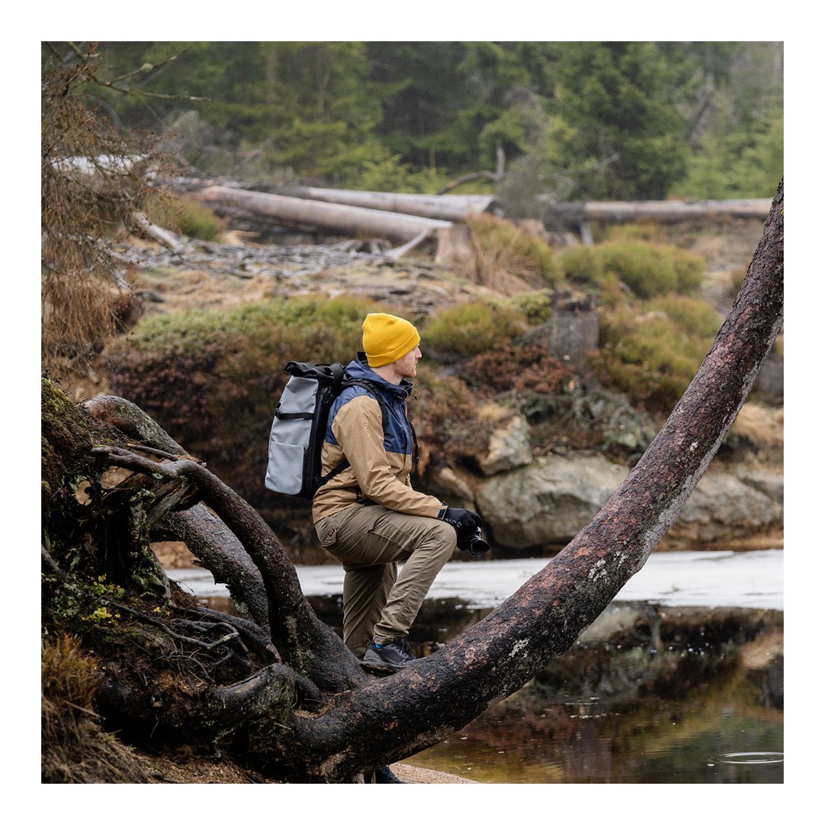 WANDRD PRVKE 41-Liter DisNet Grey Photo Bundel V3 - Anwendungsbeispiel: Person mit Rucksack, seitlich sitzend am Gewässer WANDRD PRVKE 41-Liter DisNet Grey Photo Bundel V3 - Anwendungsbeispiel: Person mit Rucksack, seitlich sitzend am Gewässer