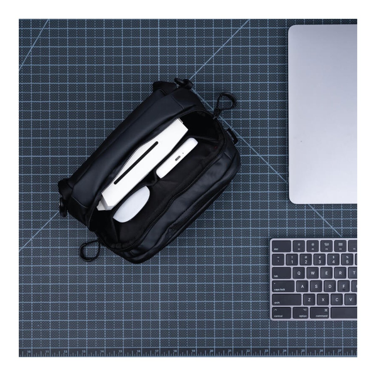 WANDRD Tech Bag Large - Grosse Organizer-Tasche (3,5 Liter) - DETAILANSICHT: Offenes Hauptfach der Tasche mit Powerbank, Smartphone und Maus.