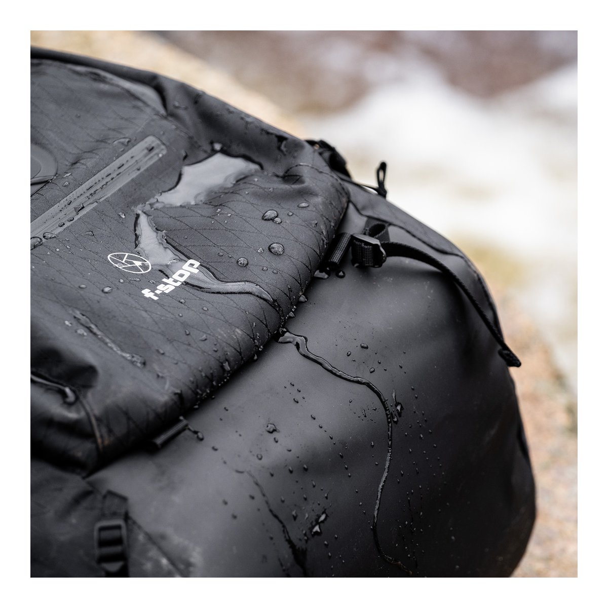 F-Stop DuraDiamond Shinn Essentials Bundle - Anthrazit - Detailansicht: Schwarzer wasserdichter Rucksack mit abperlendem Wasser und f-stop Logo.