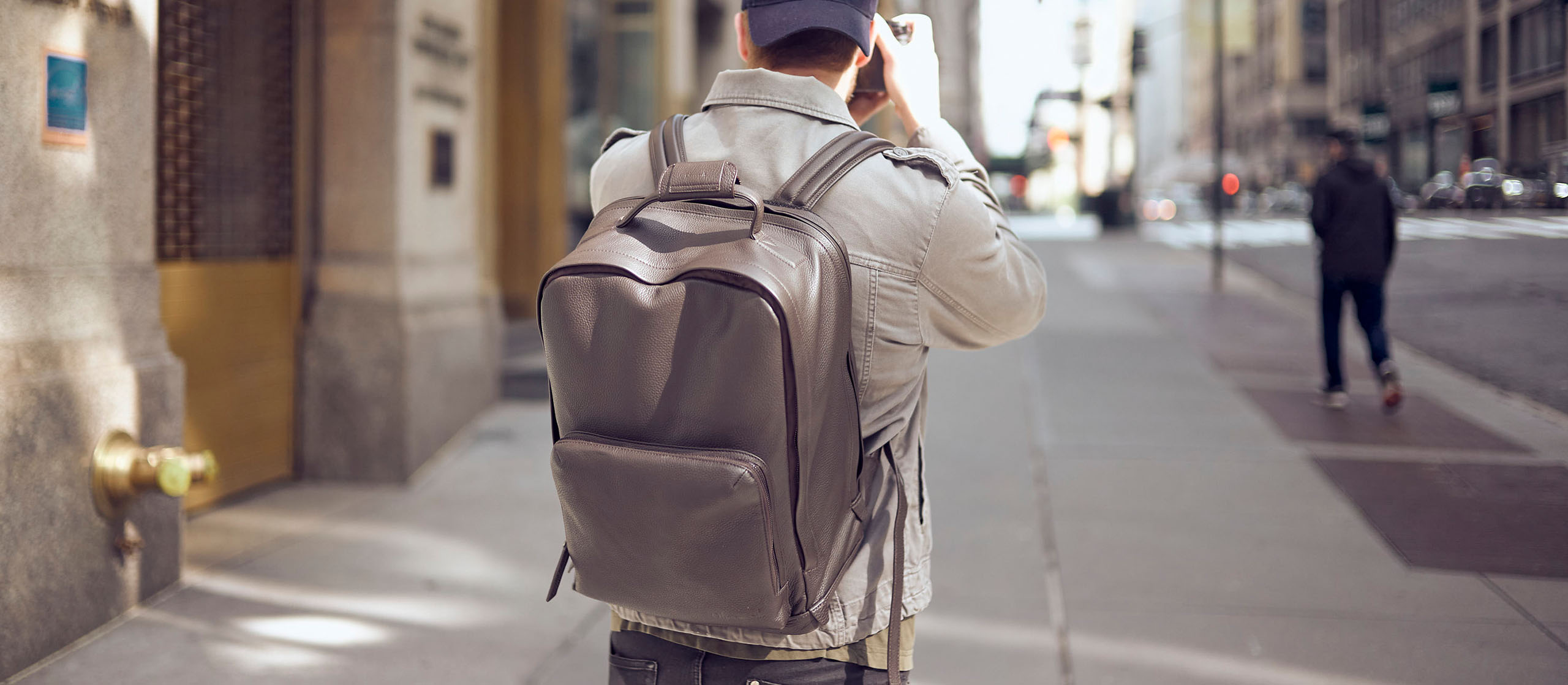 Mann mit einem Oberwerth Nelson Kamerarucksack auf dem Rücken läuft auf dem Bürgersteg einer New Yorker Straße