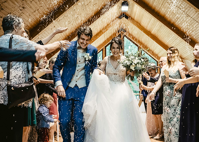 Brautpaar läuft nach der Trauung durch Konfetti – Hochzeitsreportage fotografiert mit einer Canon EOS R5 Mark II