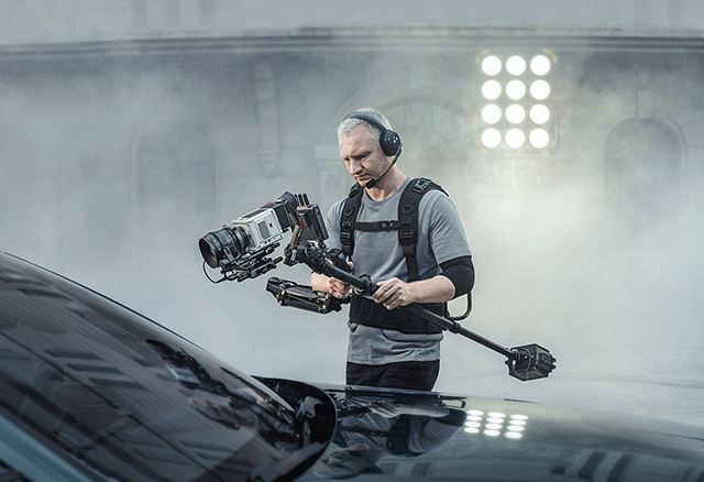 Kamermann mit einem DJI RS-3 Pro Gimbal und weiterem Equipment filmt in einem professionellen Studio