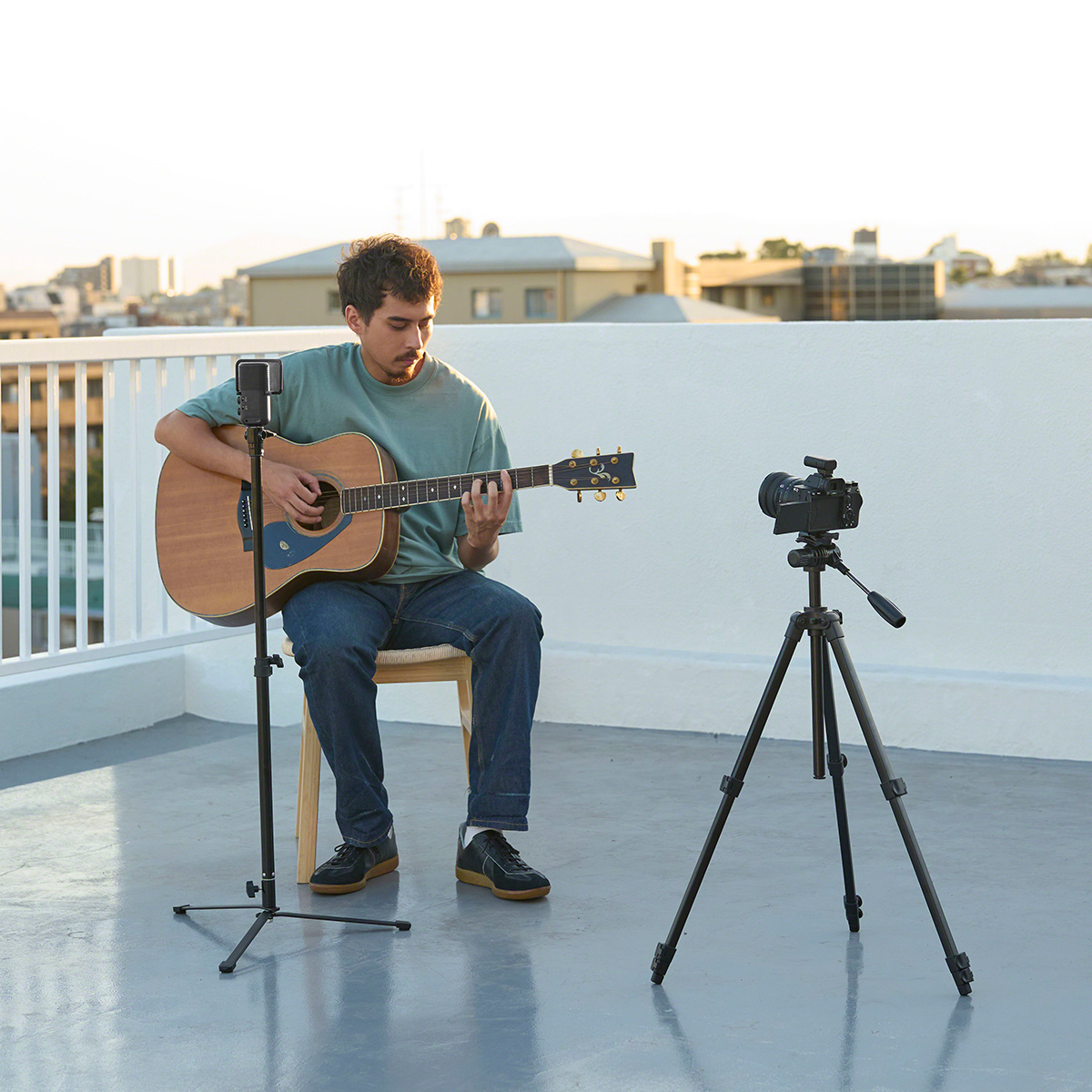 Gitarrist nimmt seine Musik mit einem Sony ECM-S1 Mikrofon auf einem Stativ auf einem Balkon auf
