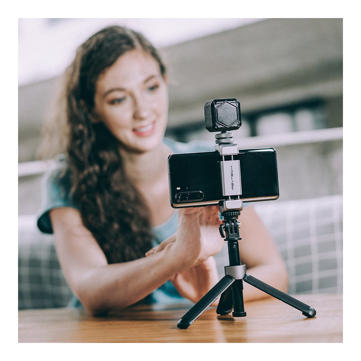 PGYTECH VLOG Phone Extension Pole Tripod - Anwendungsbeispiel: Frau nutzt Smartphone-Setup auf Tischstativ mit Zusatzlicht.