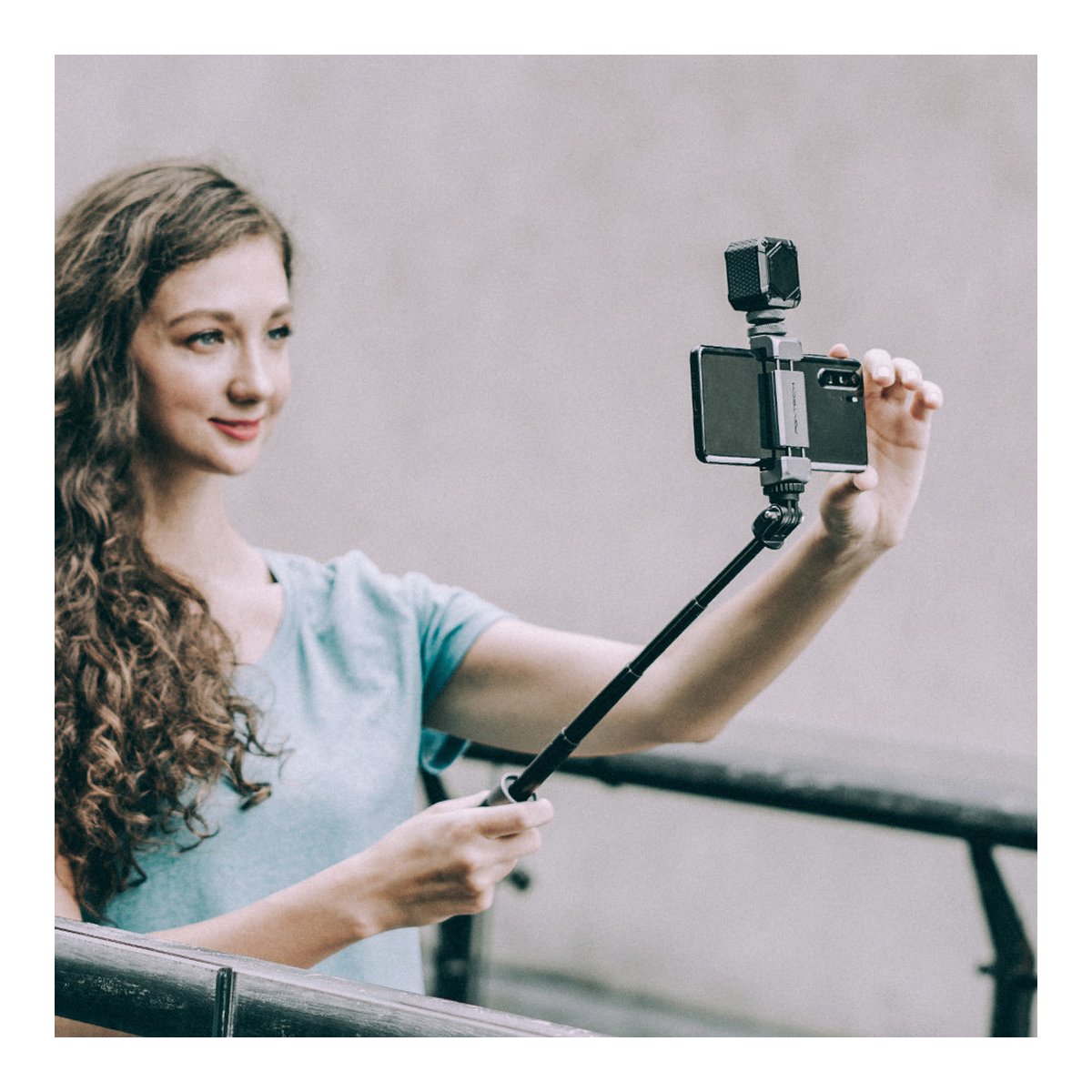 PGYTECH VLOG Phone Extension Pole Tripod - Anwendungsbeispiel: Frau filmt sich mit Selfie-Stick, Smartphone und Mikrofon.