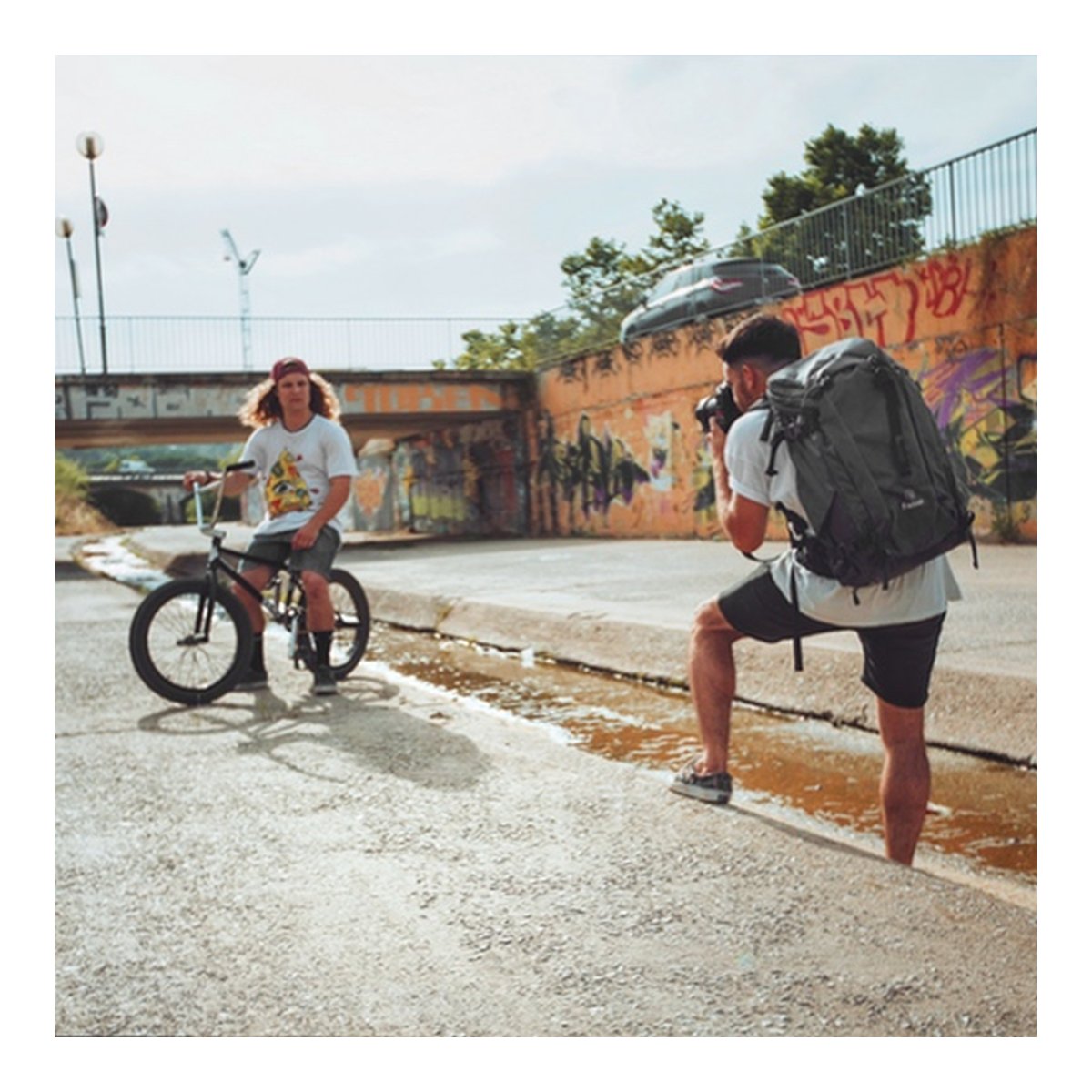 F-Stop Lotus Anthrazit (Schwarz) - Anwendungsbeispiel: Rückansicht eines Fotografen mit Rucksack beim Shooting eines BMX-Fahrers.