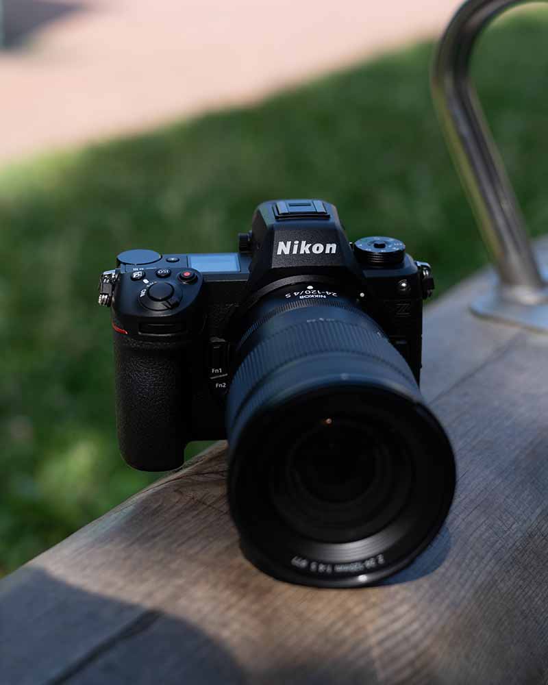 Nikon Z6 III mit Zoom-Objektiv, platziert auf einer Holzfläche im Freien. Vielseitige Vollformatkamera für Landschafts-, Porträt- und Actionfotografie.