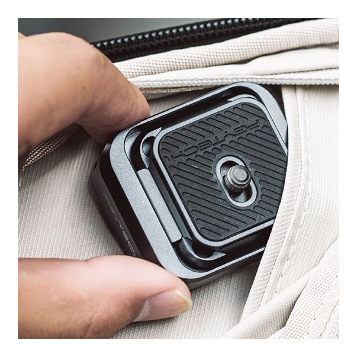 PGYTECH Arca-Type Quick Release Clamp & Plate - Anwendungsbeispiel: Eine Hand verstaut die Schnellwechselplatte in einem Taschenfach.