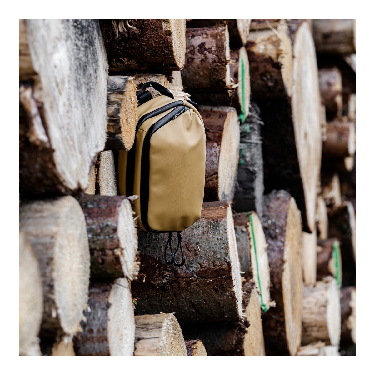 WANDRD Tech Bag Large Dallol Yellow - Beige Tasche im Holzstapel, Anwendungsbeispiel