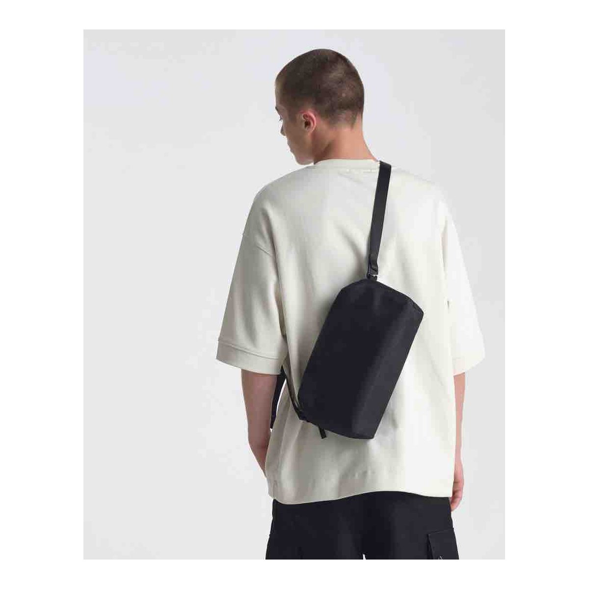 Urth Dolomite Camera Sling (Black) - Anwendungsbeispiel: Schwarze Umhängetasche auf dem Rücken getragen.