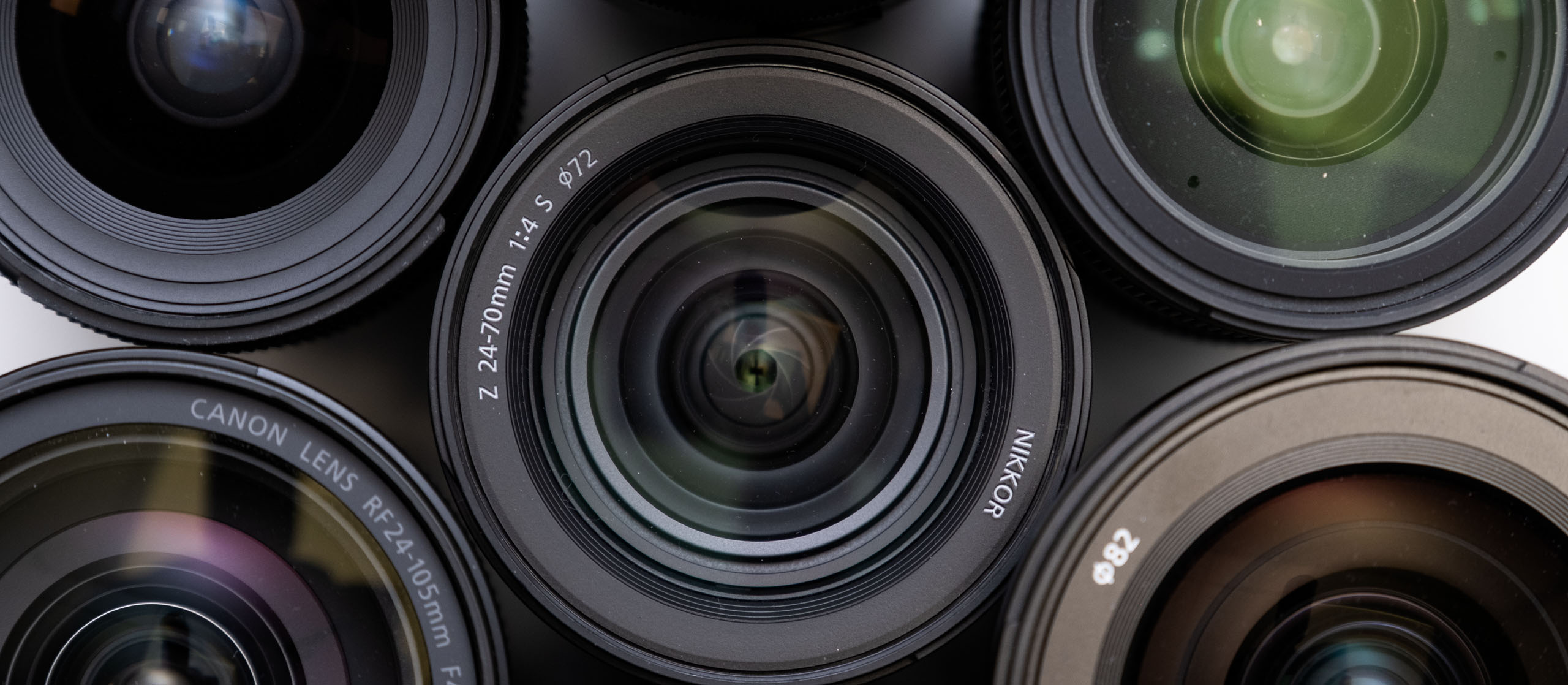 Objektivvielfalt – Auswahl an Nikon- und Canon-Objektiven für verschiedene Einsatzzwecke Verschiedene Kameraobjektive von Nikon und Canon in einer Nahaufnahme. Die Objektivvielfalt zeigt unterschiedliche Brennweiten für verschiedene Fotografie-Bereiche.