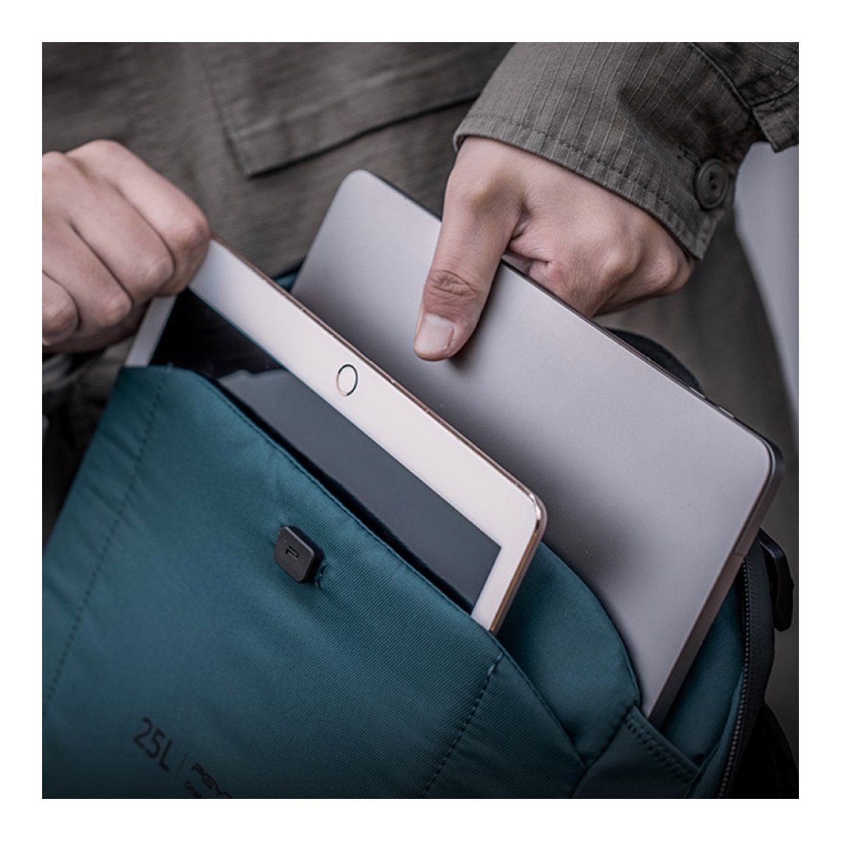 PGYTECH OneMo 2 Backpack 25L (Space Black) - Detailansicht: Hände verstauen Tablet und Laptop im Laptopfach des Rucksacks.