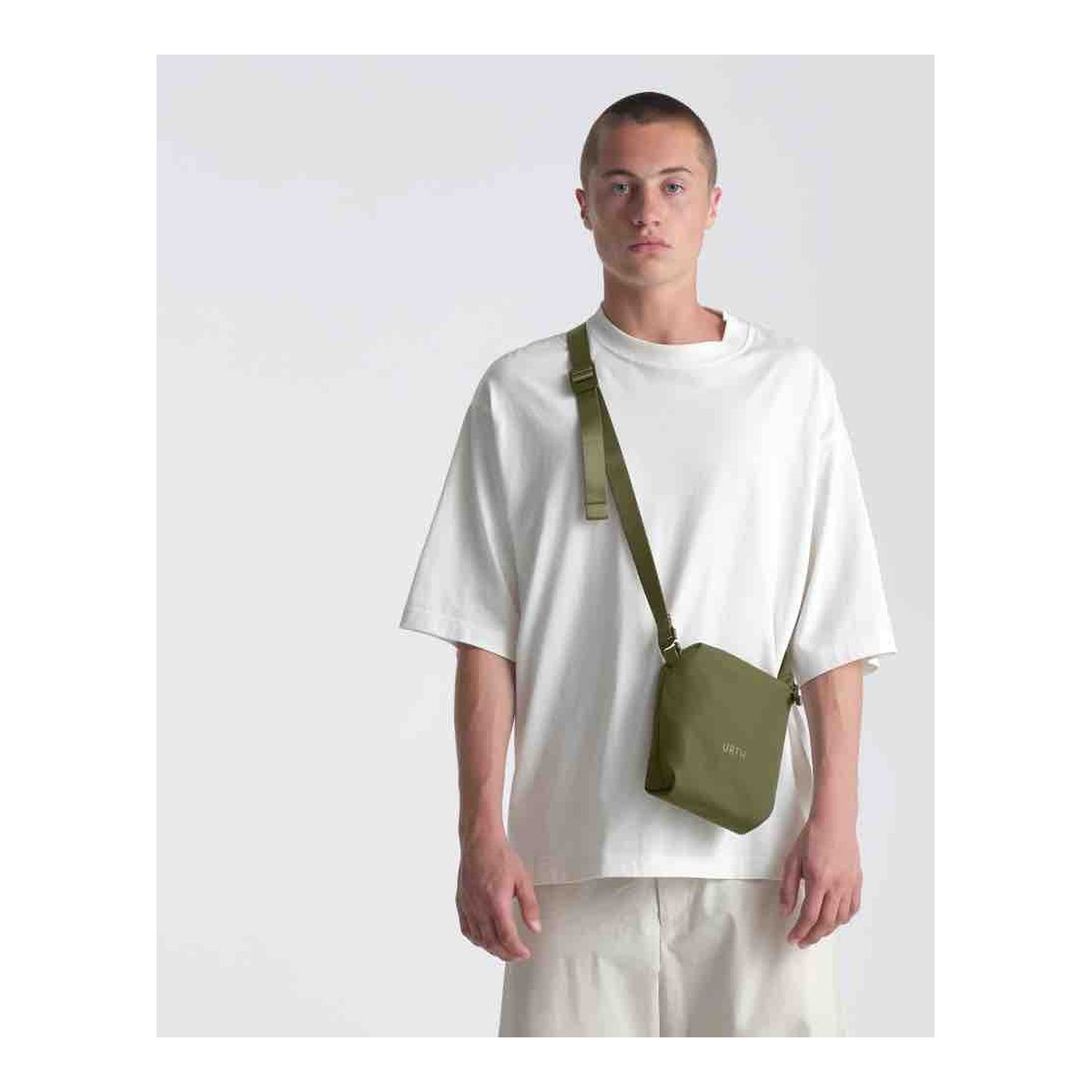 Urth Andesite Camera Pouch (Green) - Anwendungsbeispiel: Model trägt grüne Umhängetasche frontal. Urth Andesite Camera Pouch (Green) - Anwendungsbeispiel: Model trägt grüne Umhängetasche frontal.