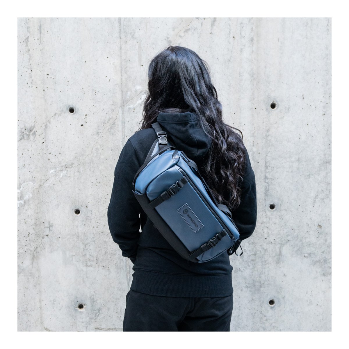 WANDRD ROGUE Sling 9L Aegean Blue - Anwendungsbeispiel: Rückansicht einer Person mit blauer Sling Bag. WANDRD ROGUE Sling 9L Aegean Blue - Anwendungsbeispiel: Rückansicht einer Person mit blauer Sling Bag.