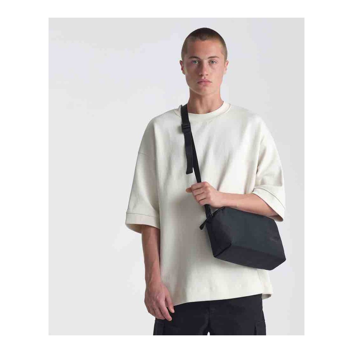 Urth Dolomite Camera Sling (Black) - Anwendungsbeispiel: Person trägt die schwarze Umhängetasche schräg von vorne